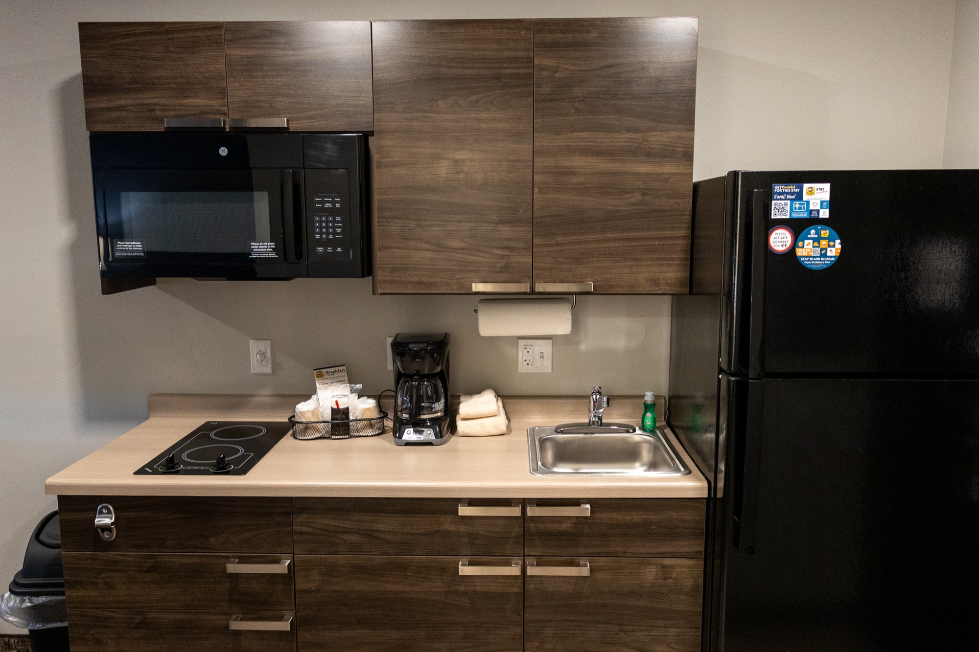 In-room kitchen at My Place Hotel Jonesboro with cooktop, microwave, full-size refrigerator and sink