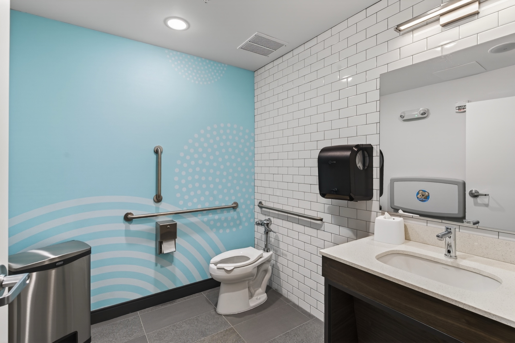 Guest bathroom with subway tile and a teal graphic accent wall