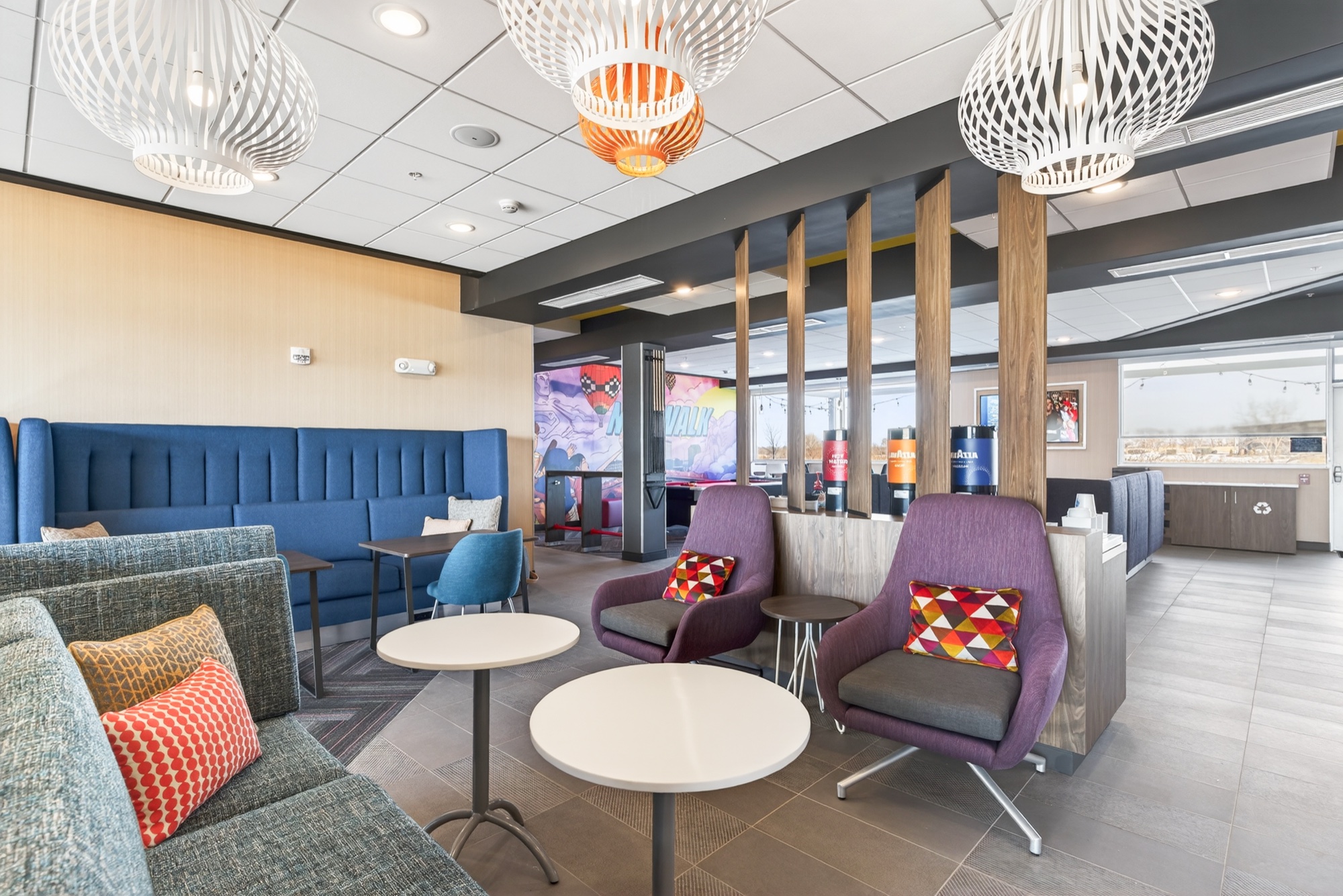 Lobby lounge with seating, pendant lights and cafe tables