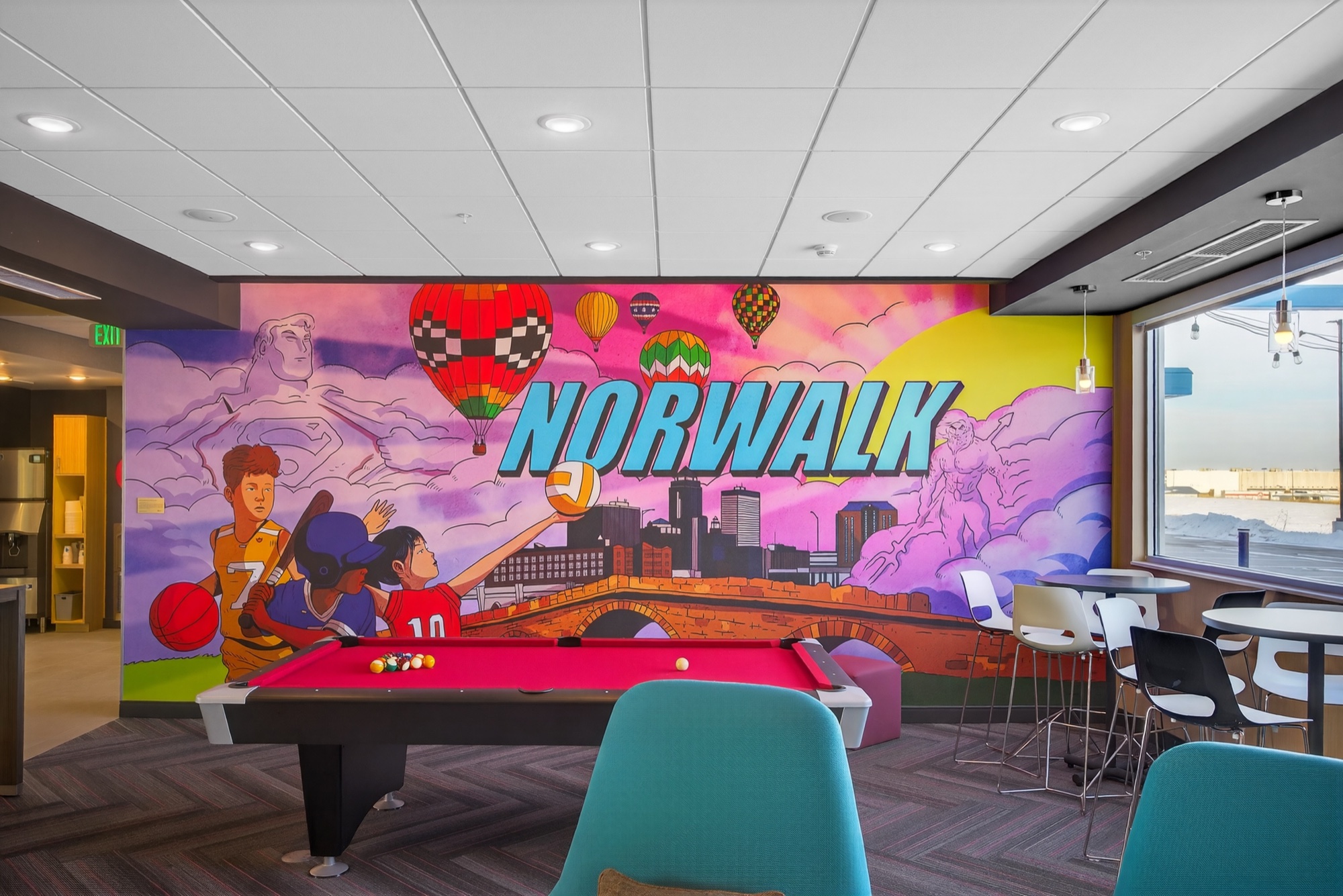 Norwalk mural and pool table in the hotel common area