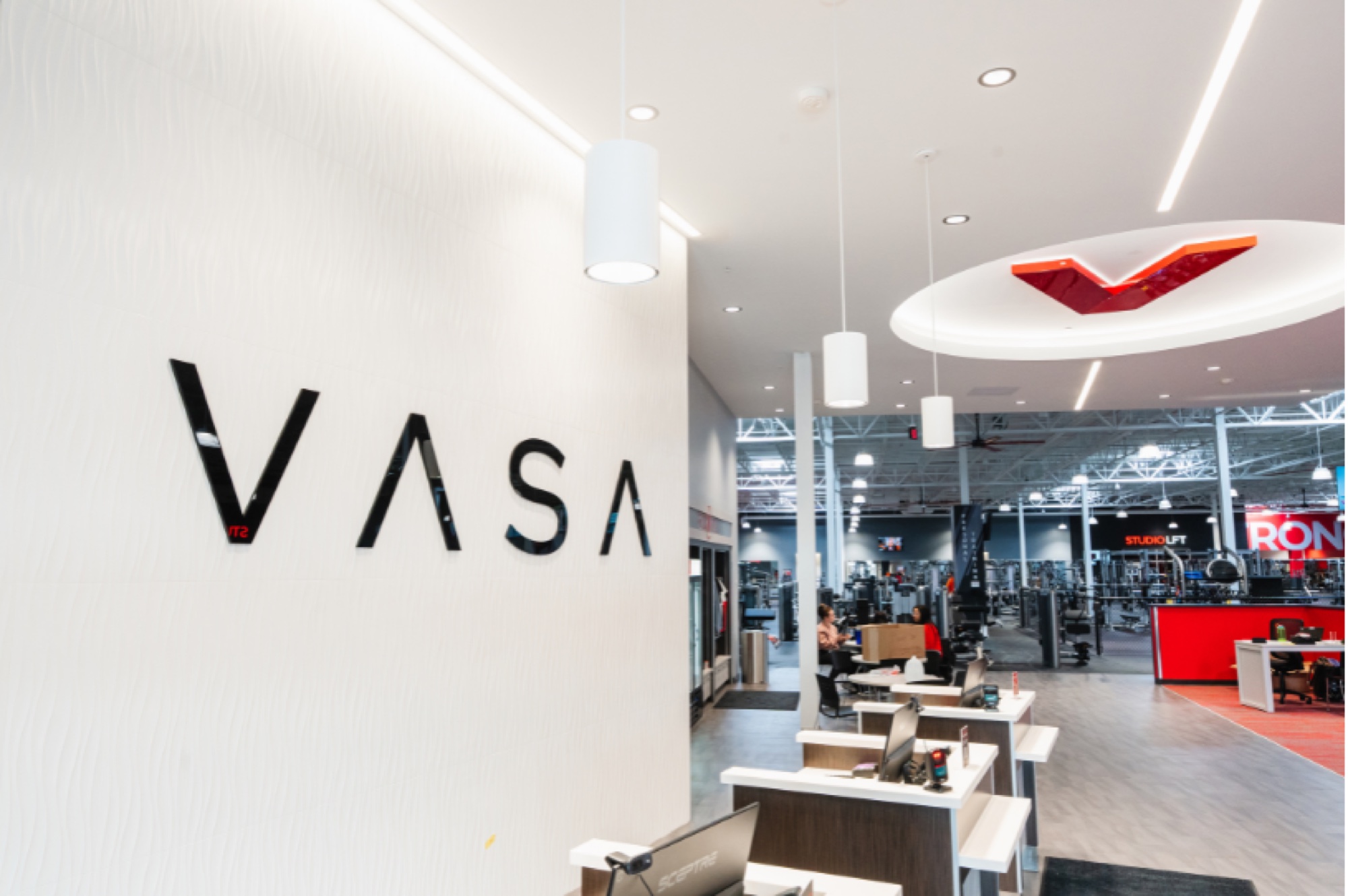 Entry at VASA Fitness Castleton with the VASA wordmark on the wall and the weight floor beyond