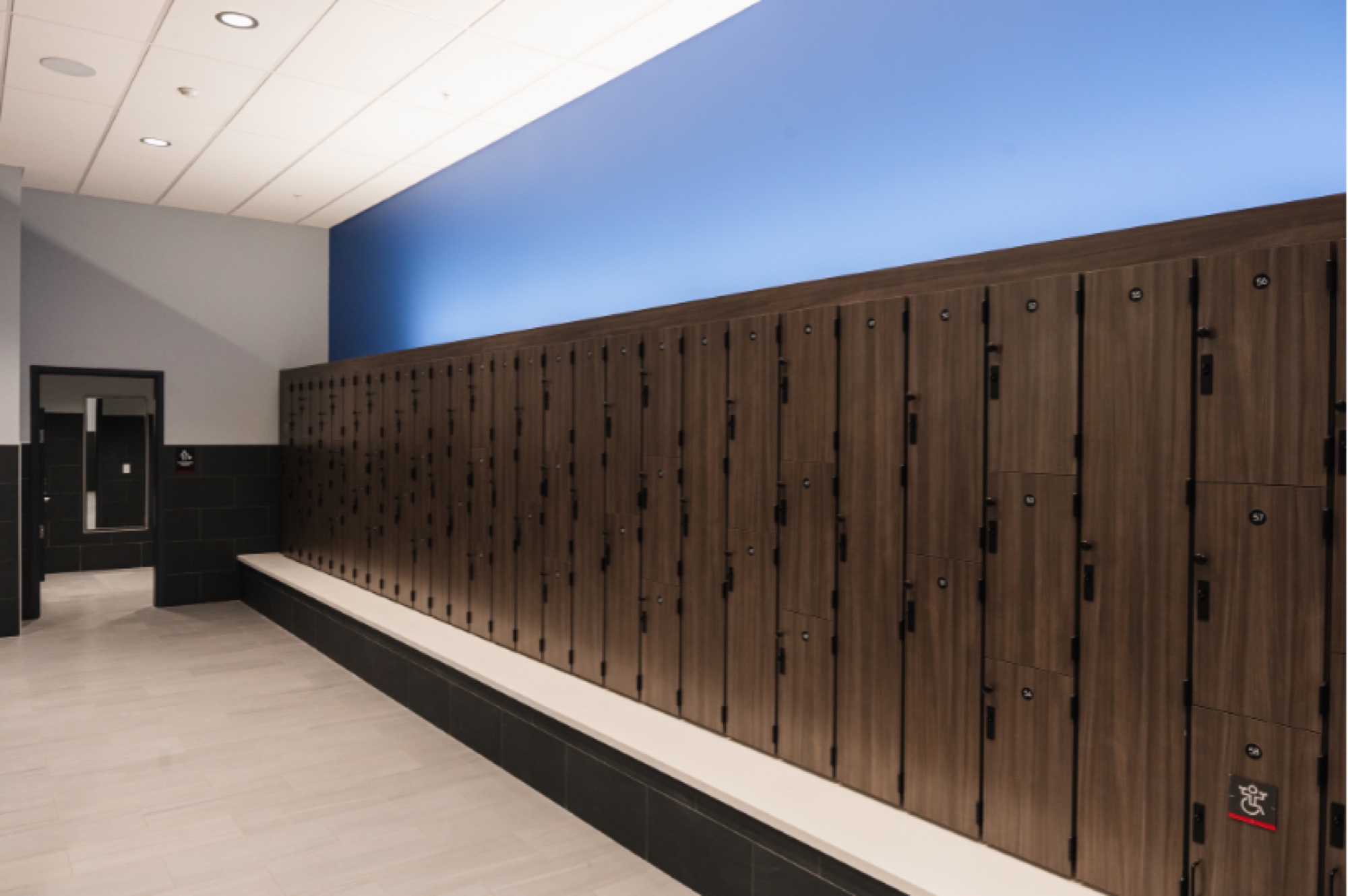 Locker room with wood front lockers and bench seating at VASA Fitness Castleton